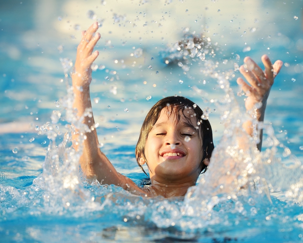 Kid splashing on summer pool Kid splashing on summer pool
